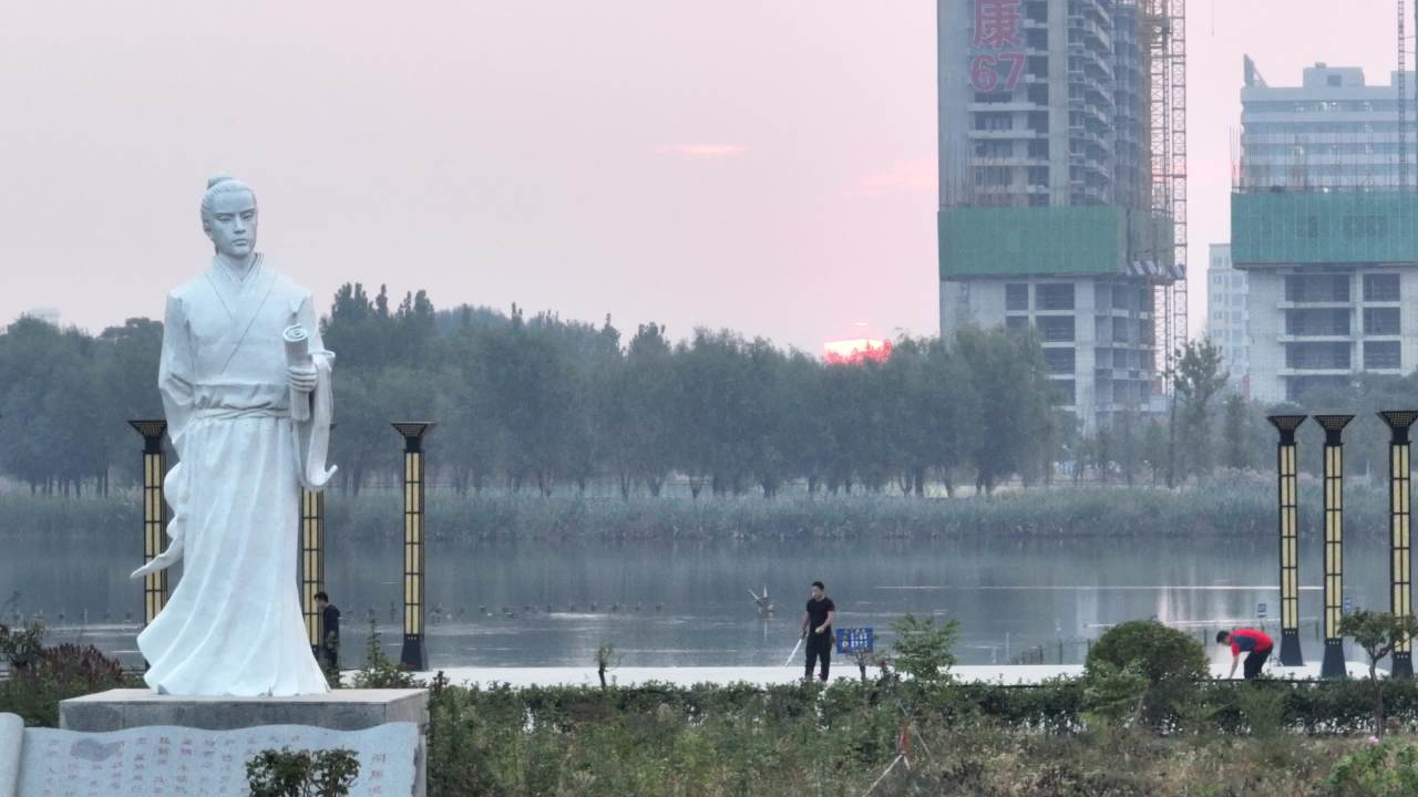 湖畔雕像与行人