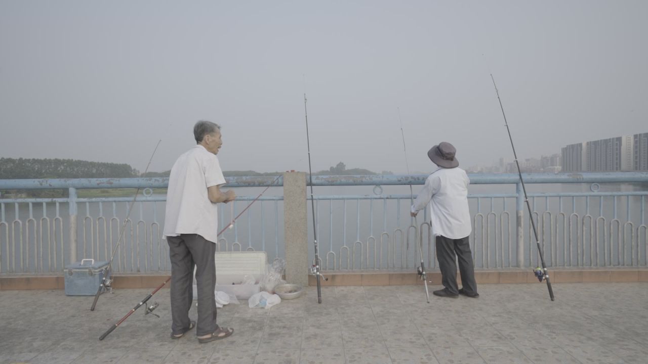 大爷边钓鱼边聊天