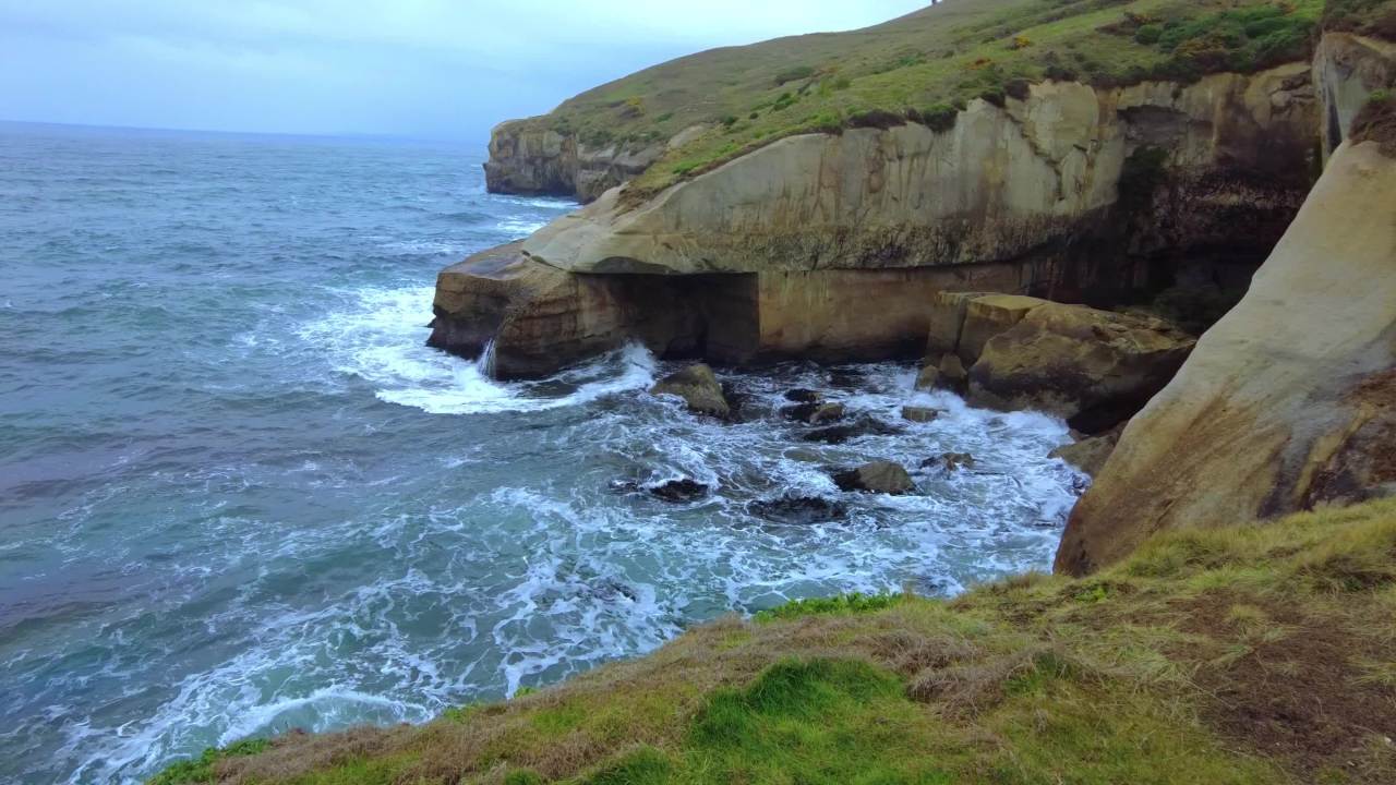 新西兰达尼丁隧道海滩海浪冲刷着海边巨大礁石 3