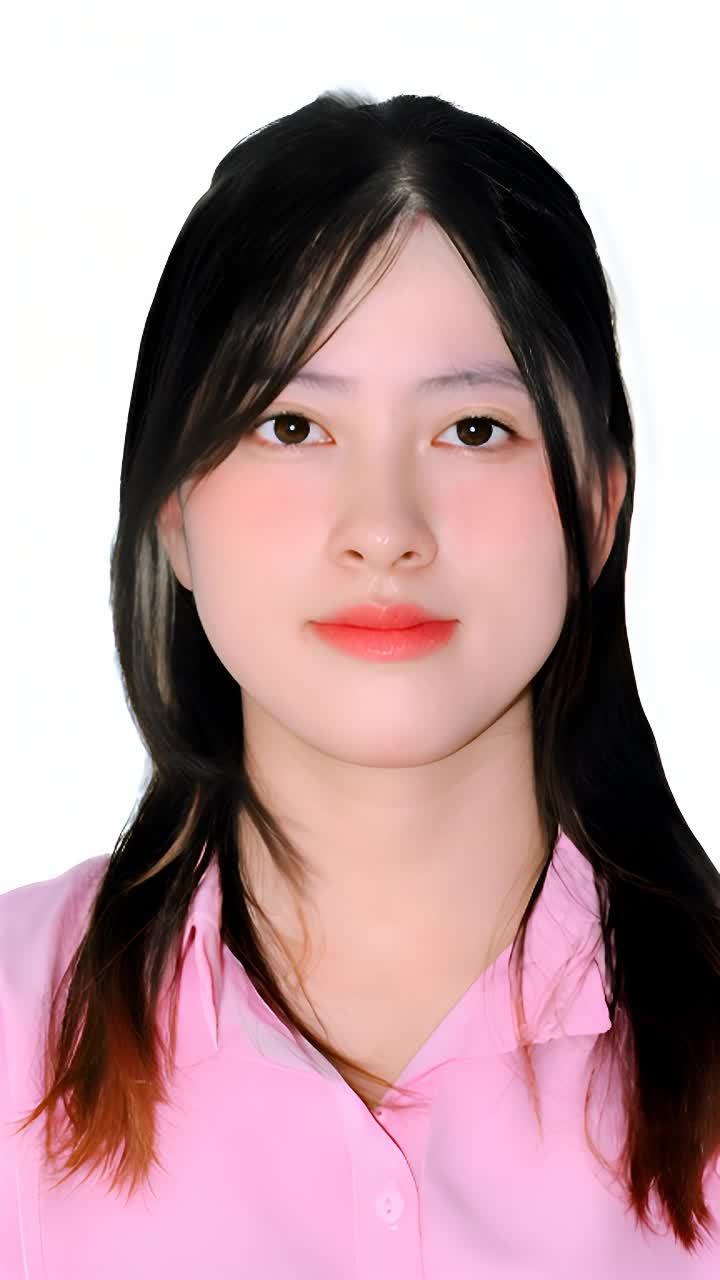 一个有着黑色长发的女子，嘴唇涂着粉色，她穿着一件粉
