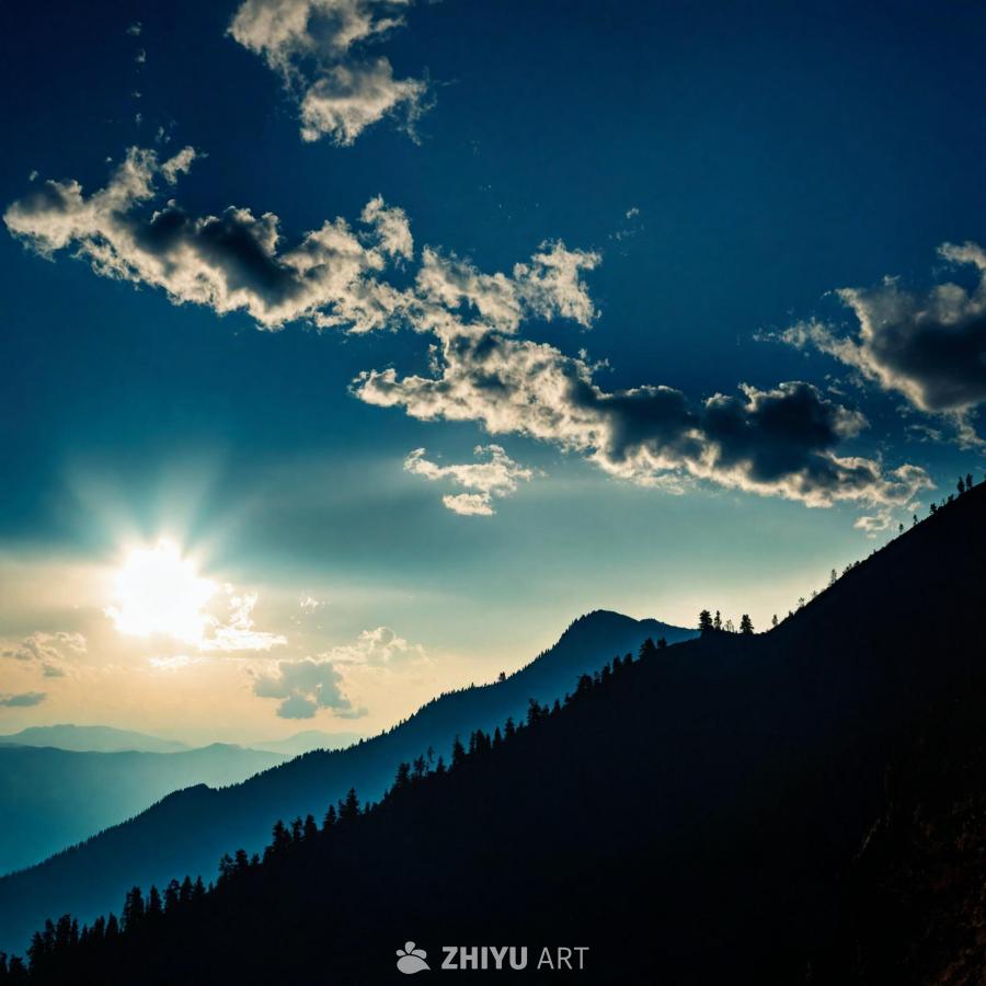 深蓝色的天空，阳光穿过云层。远景中可见山脉，其山峰