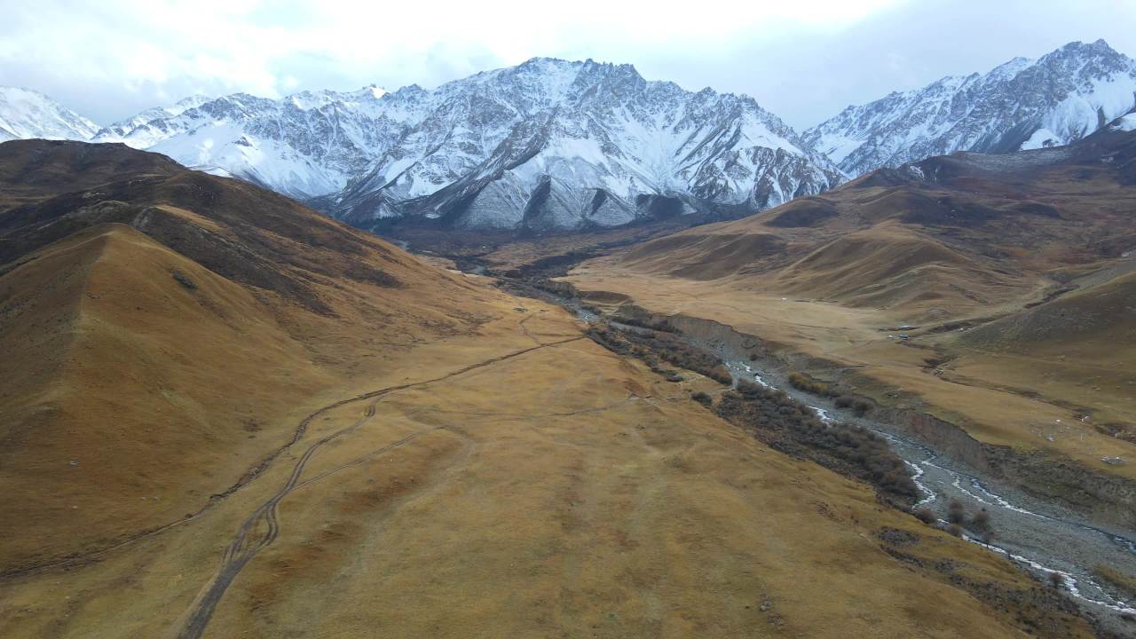 青海海北祁连县二尕公路上航拍祁连雪山峡谷溪流和黄色