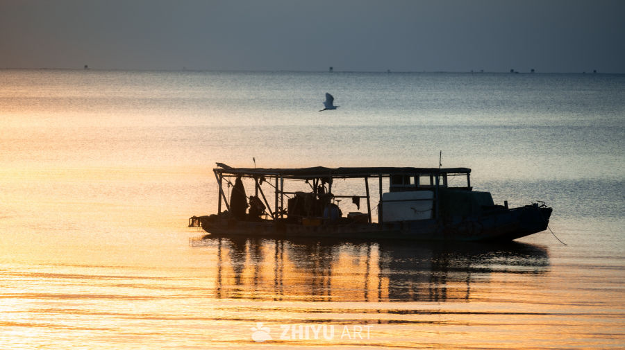 夕阳下的渔船剪影