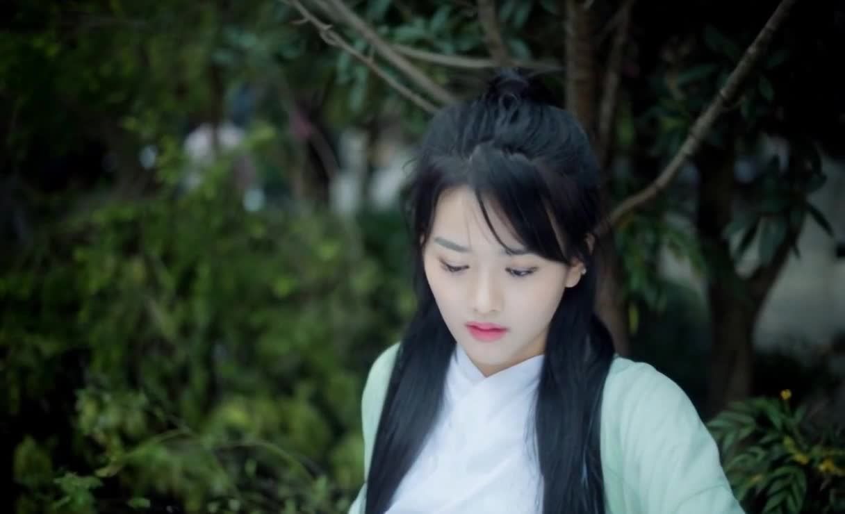 身穿浅绿衣裳的黑发女子注视着镜头
