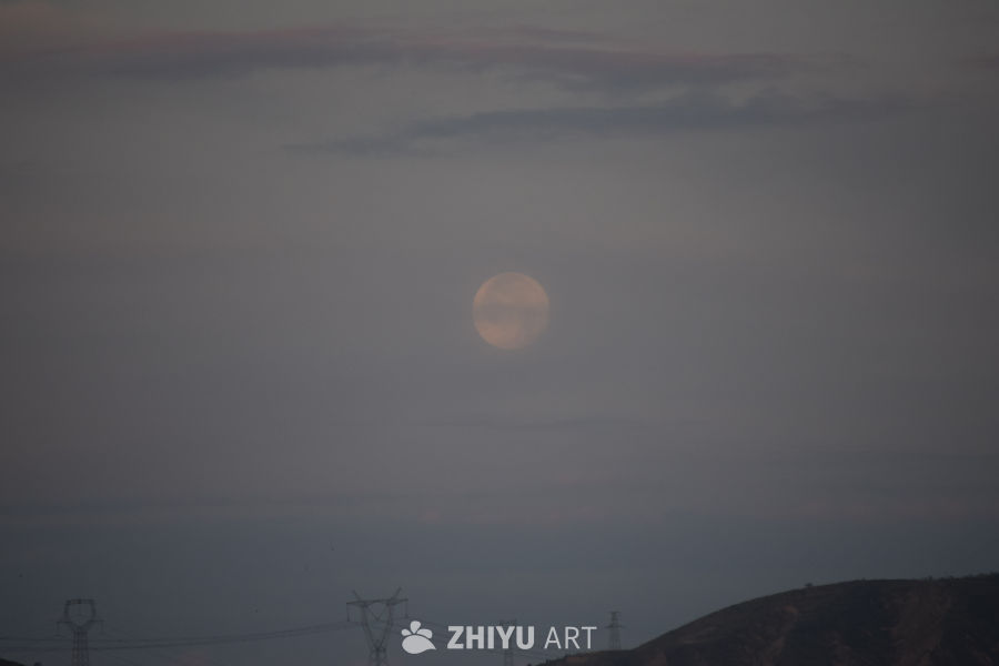 黄昏中的月亮与电力塔
