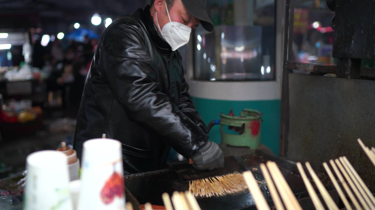 夜市摊主忙碌的烹饪时光