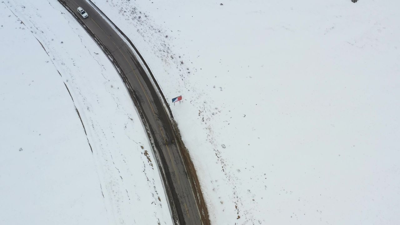 航拍汽车行驶在冰天雪地的川藏公路上