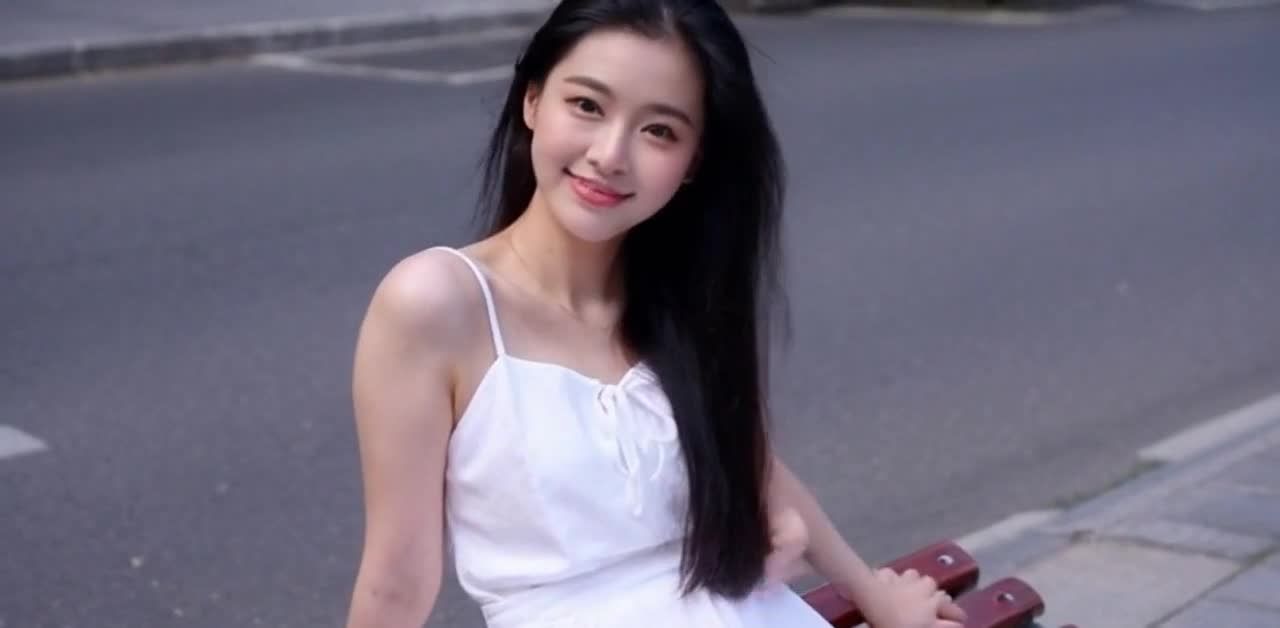 街道长椅上的白裙微笑少女