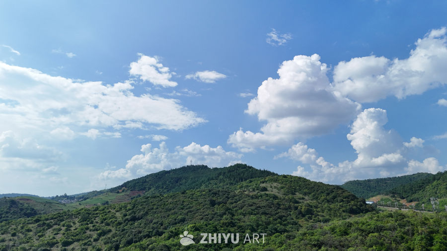 蓝天白云下的绿意山丘