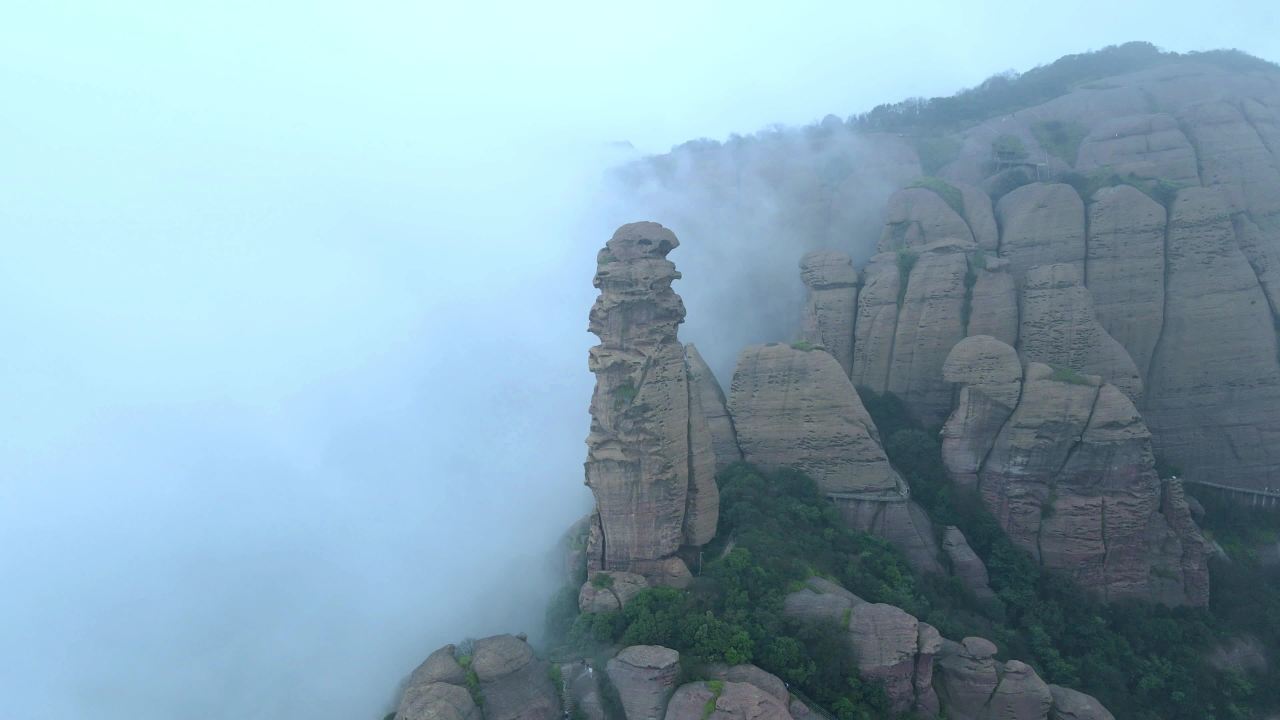 航拍雾中江西上饶弋阳龟峰景区丹霞地貌的石柱山体和森林 4