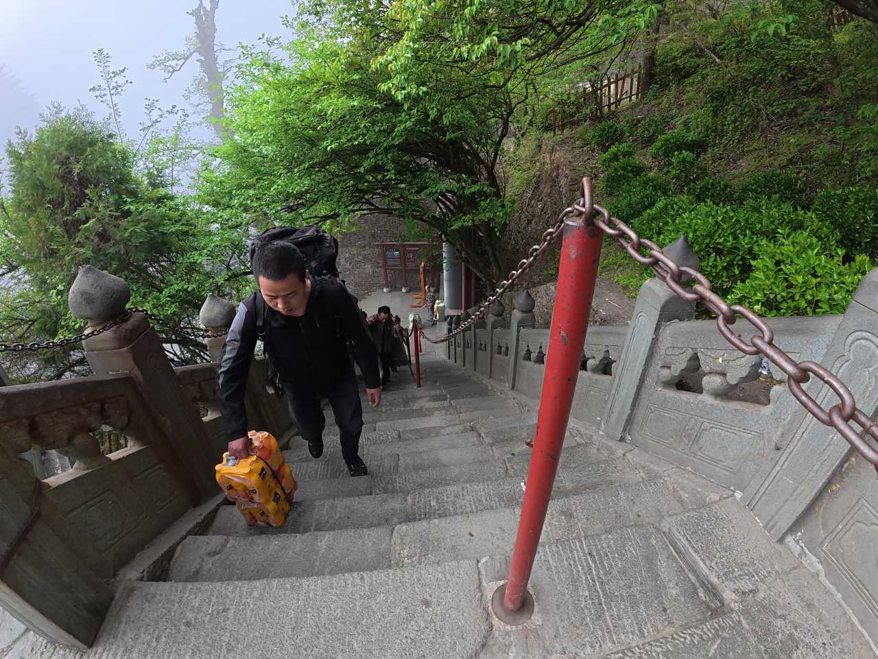雾中登山：背篓与游客的旅程