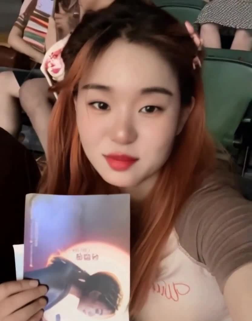 一个年轻女子，头发是红棕色，头戴粉色发夹，穿着一件