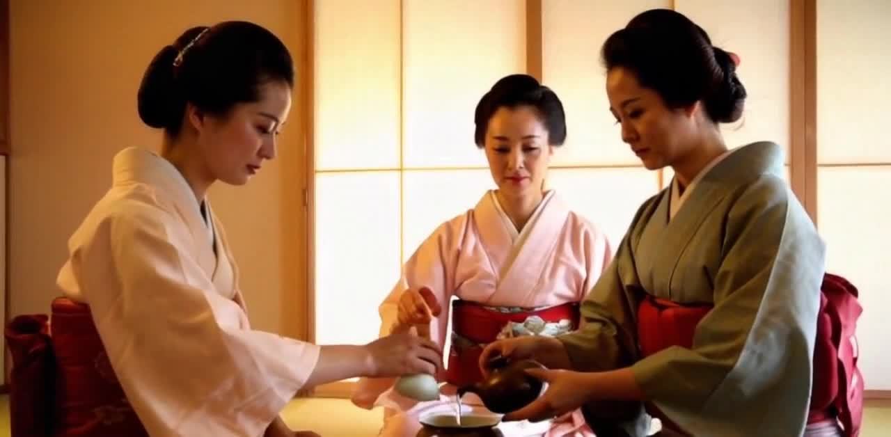 三位身着和服的女性正在室内进行茶道表演。她们分坐在