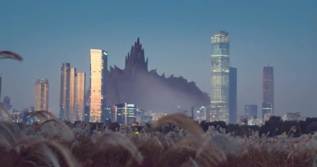 夜幕下城市高楼耸立，杂草摇曳，天空湛蓝