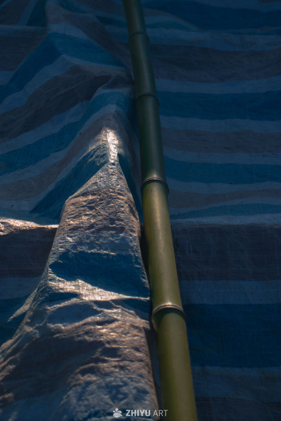 竹竿与防水布的光影交错