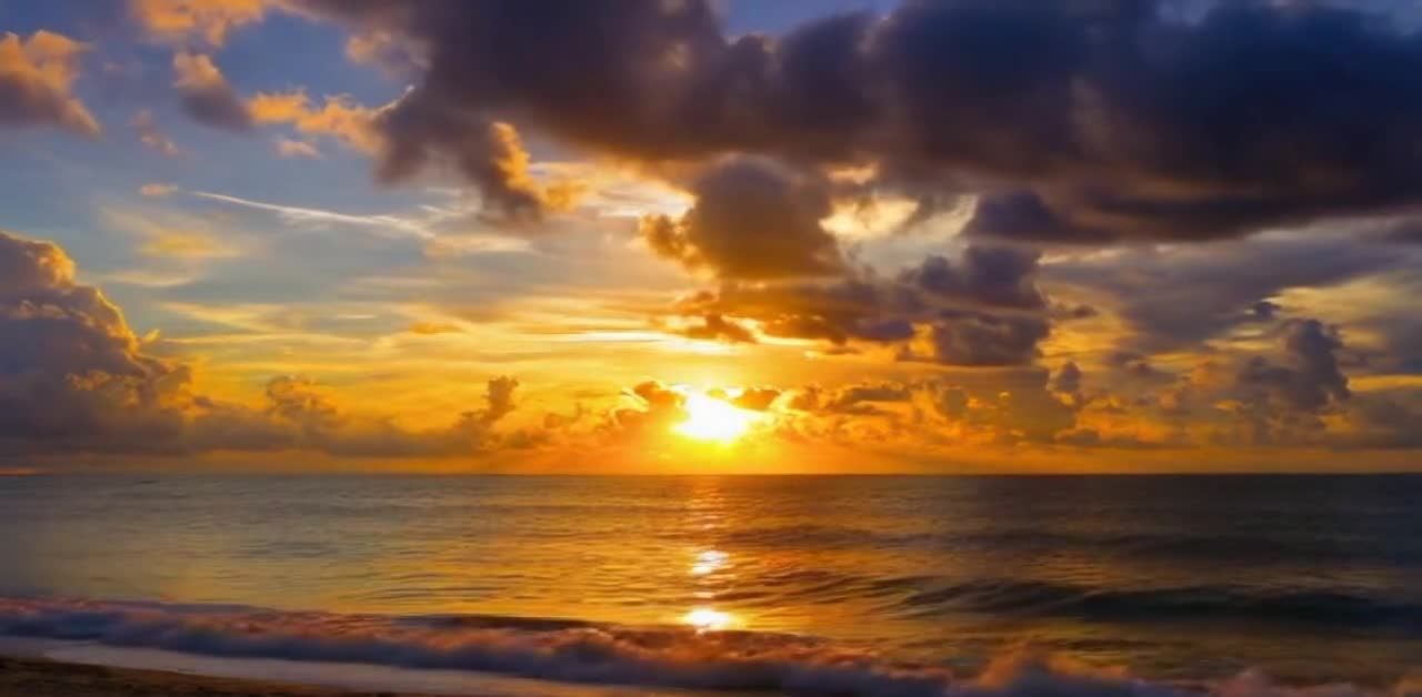 壮丽的海边日落景象。天空中分布着橙色、黄色、深蓝色