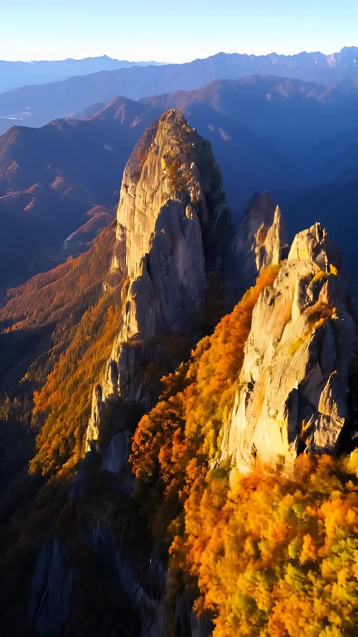 高耸入云的山峰，沐浴在金色的秋日阳光下。山峰的岩石