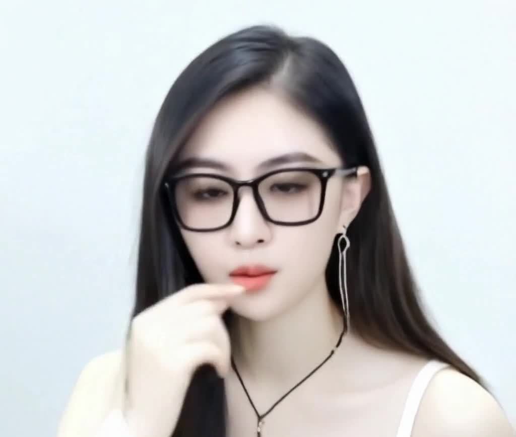 戴黑框眼镜的年轻女性沉思状特写照