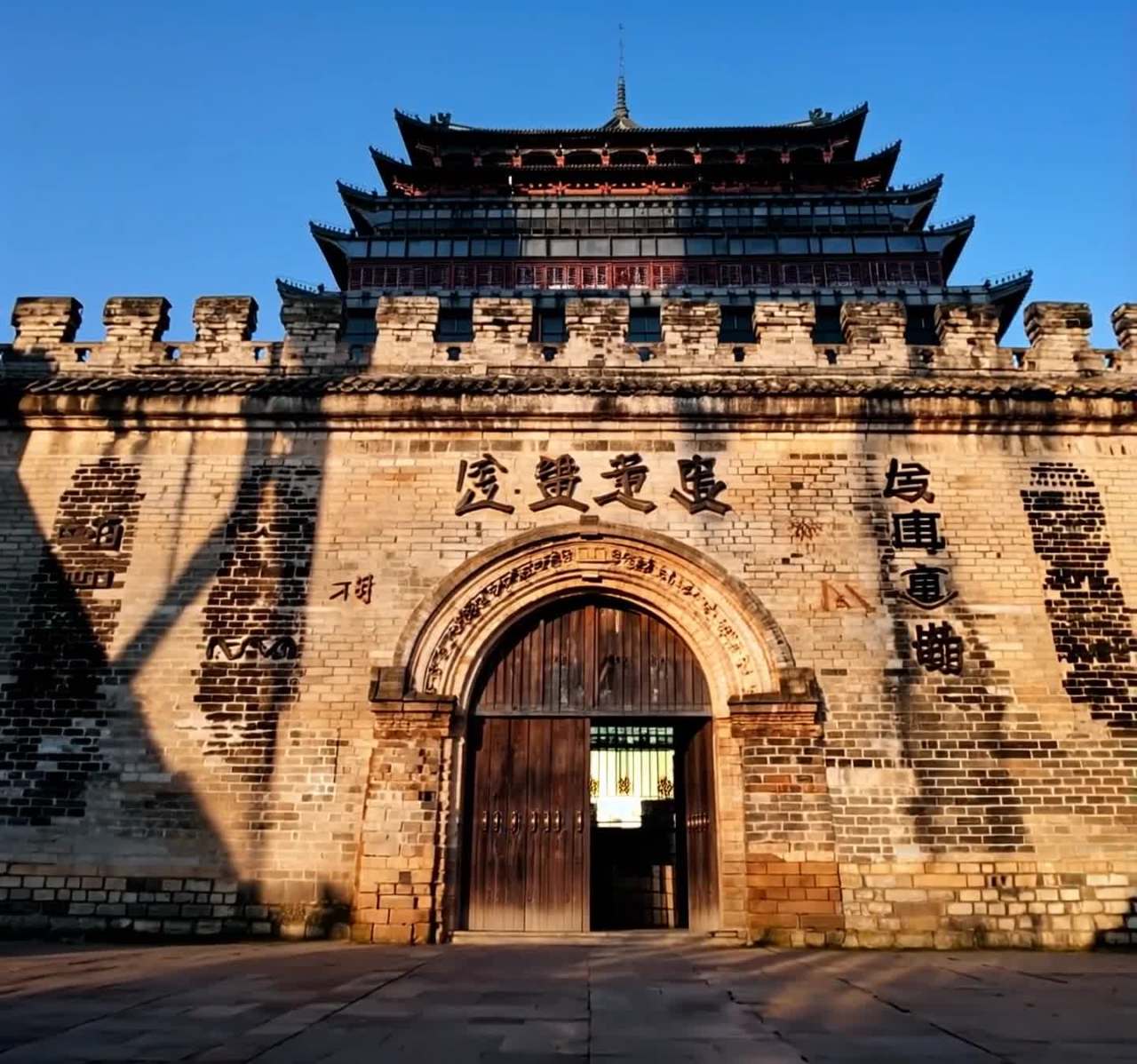 一座中国古老建筑的正大门，石墙细节丰富，在晨光中显