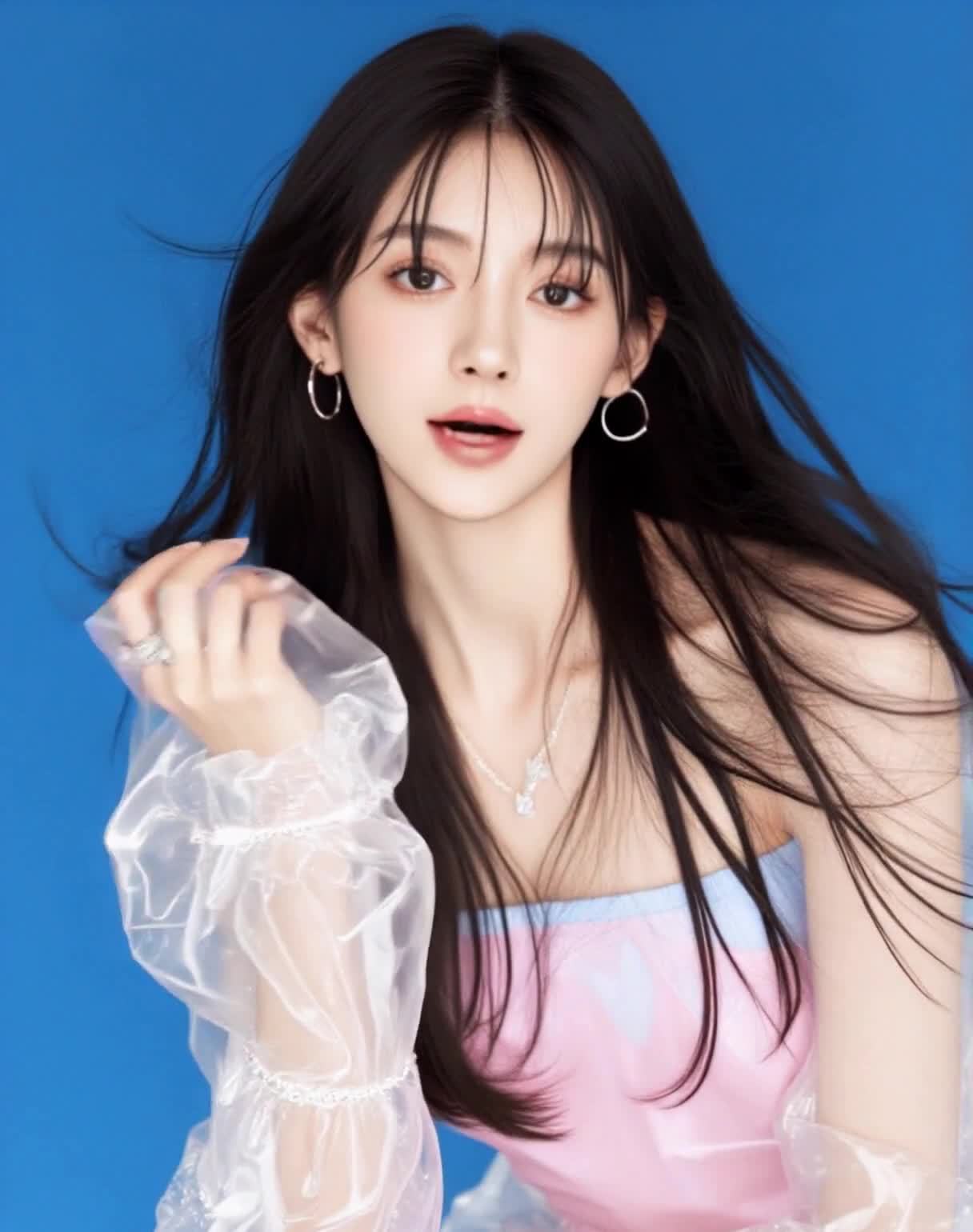 一位长发披肩的女性正对着镜头。她佩戴着一对圆形耳环