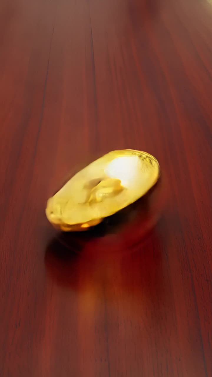一个金色的比特币躺在桌子上，开始剧烈摇晃。它分裂成
