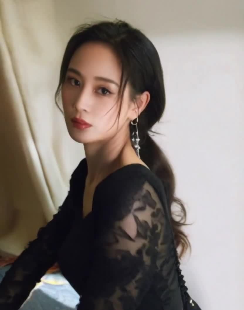 精致妆容女性凝视镜头，黑色着装佩戴耳环写真