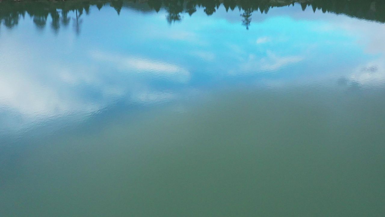 航拍蓝调时分玉隆拉错湖边树木的倒影