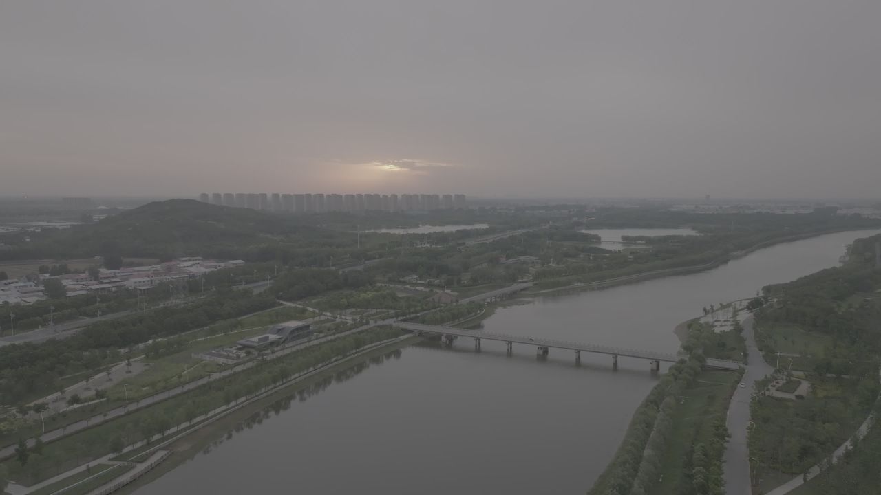 城市日落下的河流与绿意