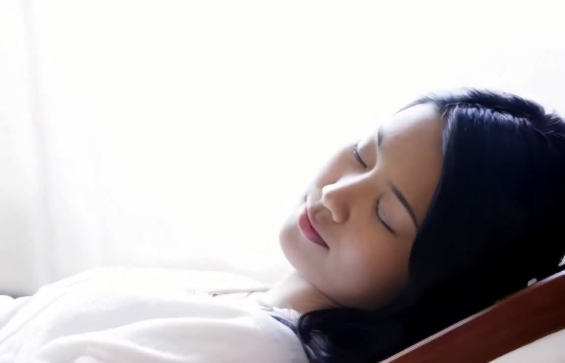闭眼女子侧躺，头部特写，阳光，黑发，平静安详。