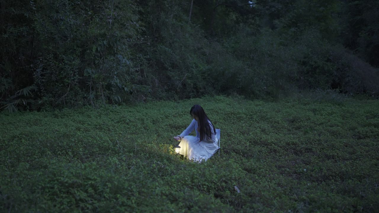 【4KHDR原始素材】美女在草丛中缓慢提起露营灯