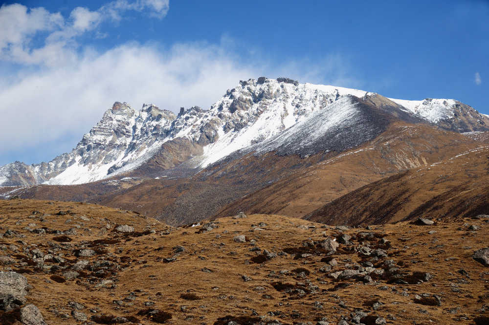 西藏蓝天下黄色岩土和白色雪山