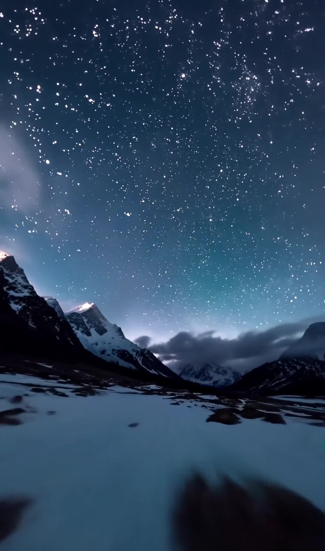 夜晚，雪山在昏暗的蓝色氛围中，可见云雾缭绕，拍摄视
