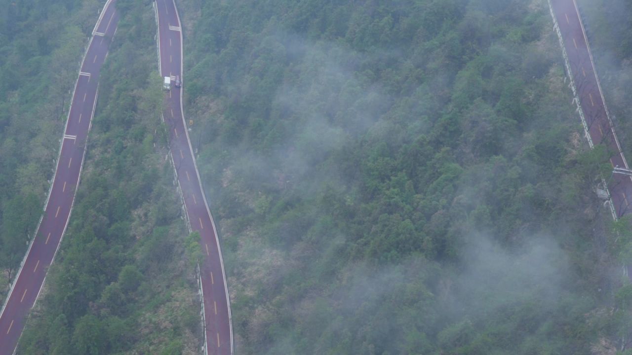 雨雾天汽车行驶在矮寨大桥的盘山公路上