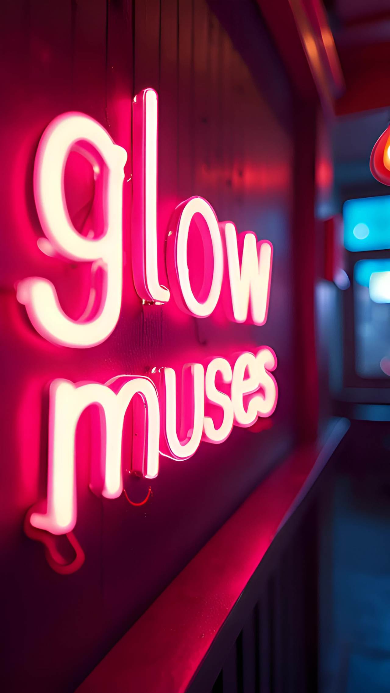 粉色的霓虹灯字“glow muses”悬挂在深色的