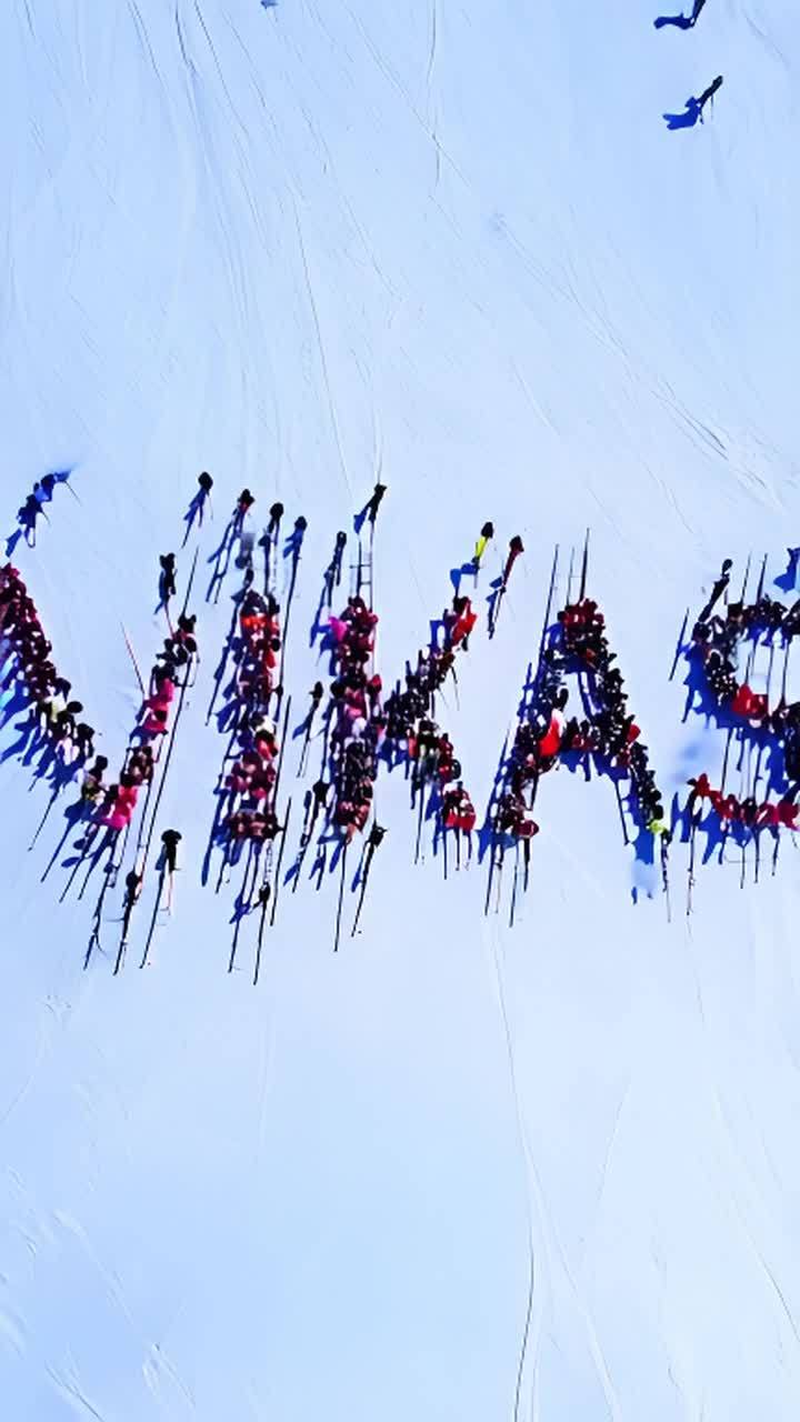 滑雪场上，许多滑雪者排列成VIKAS字样。镜头拉近