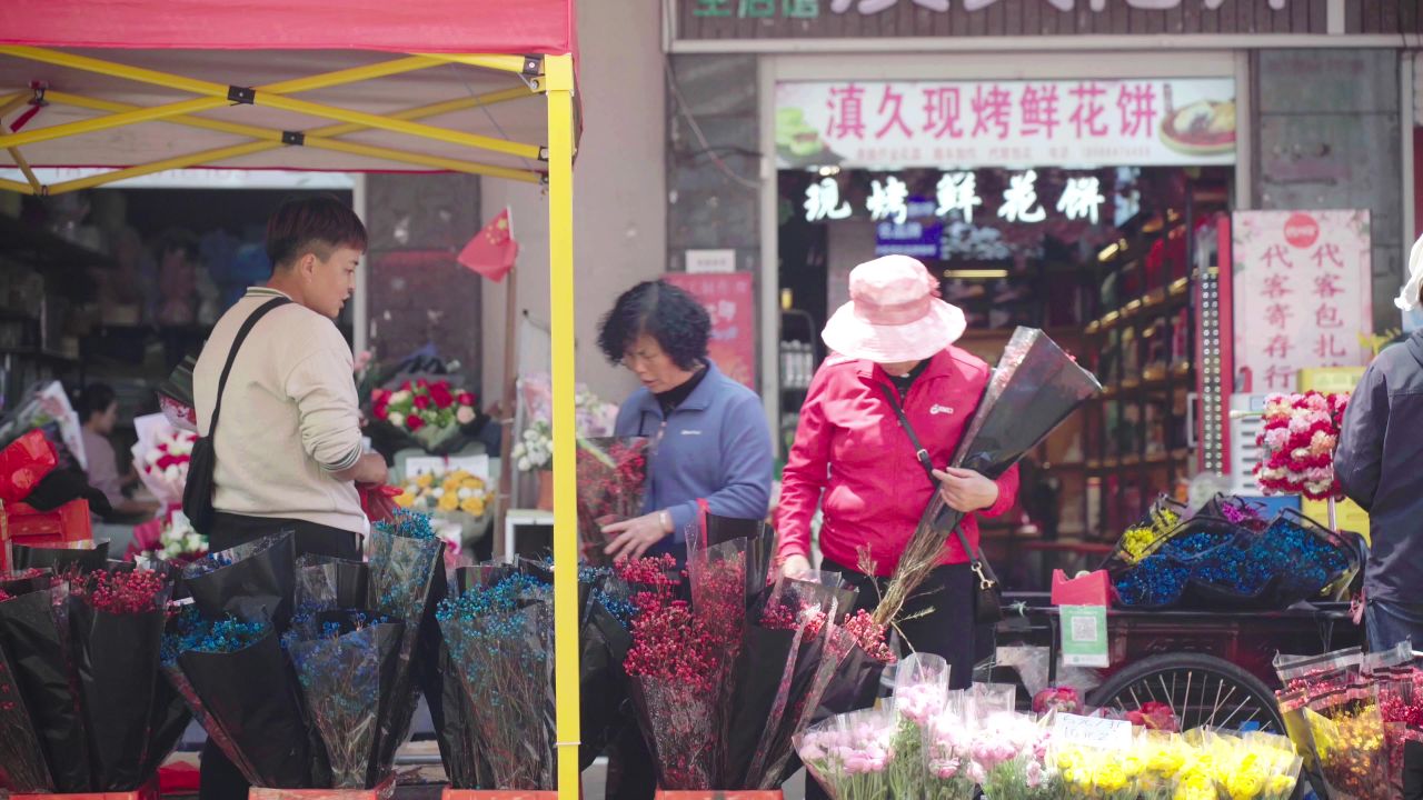  昆明斗南花市正在买花的女士