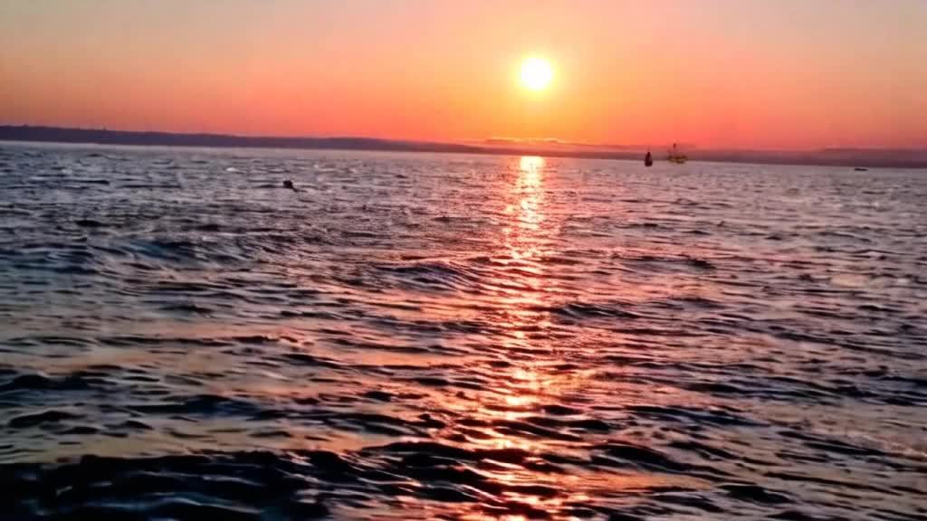 夕阳西下，宁静而壮丽的金色余晖在海面上缓缓展开。天