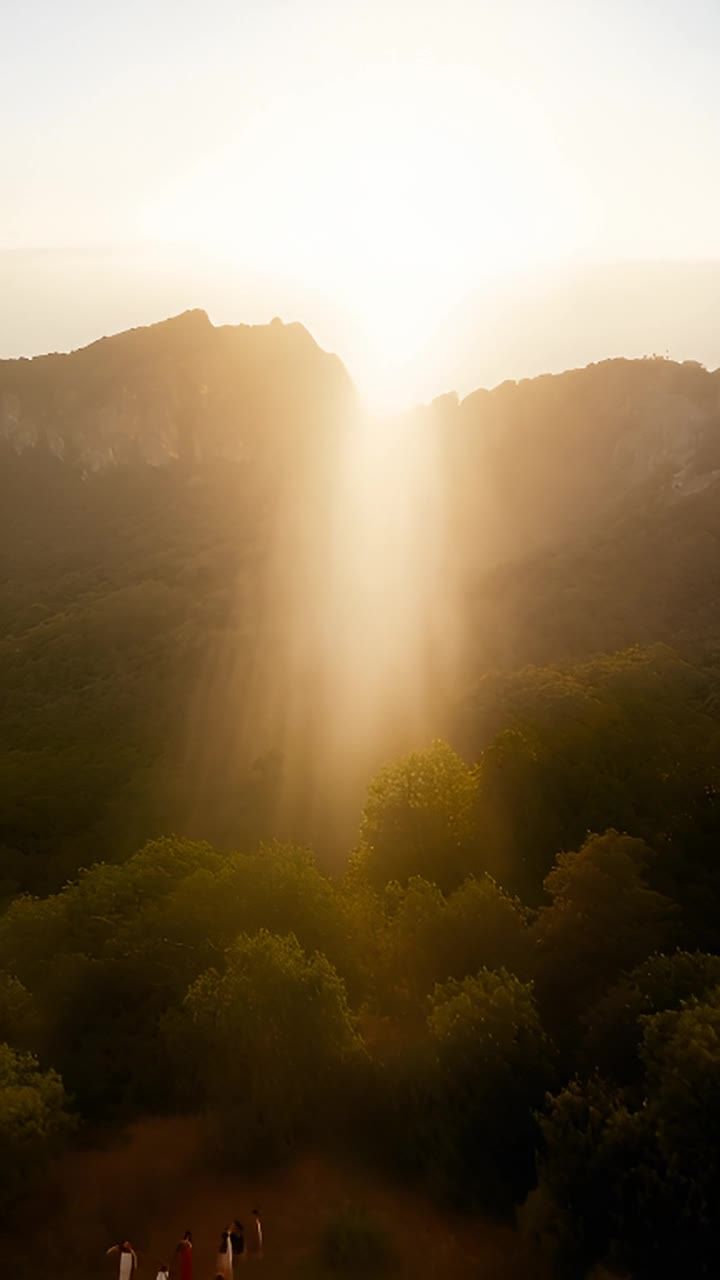 清晨时分，神圣的山峦被明亮的金色光芒笼罩。一道光束