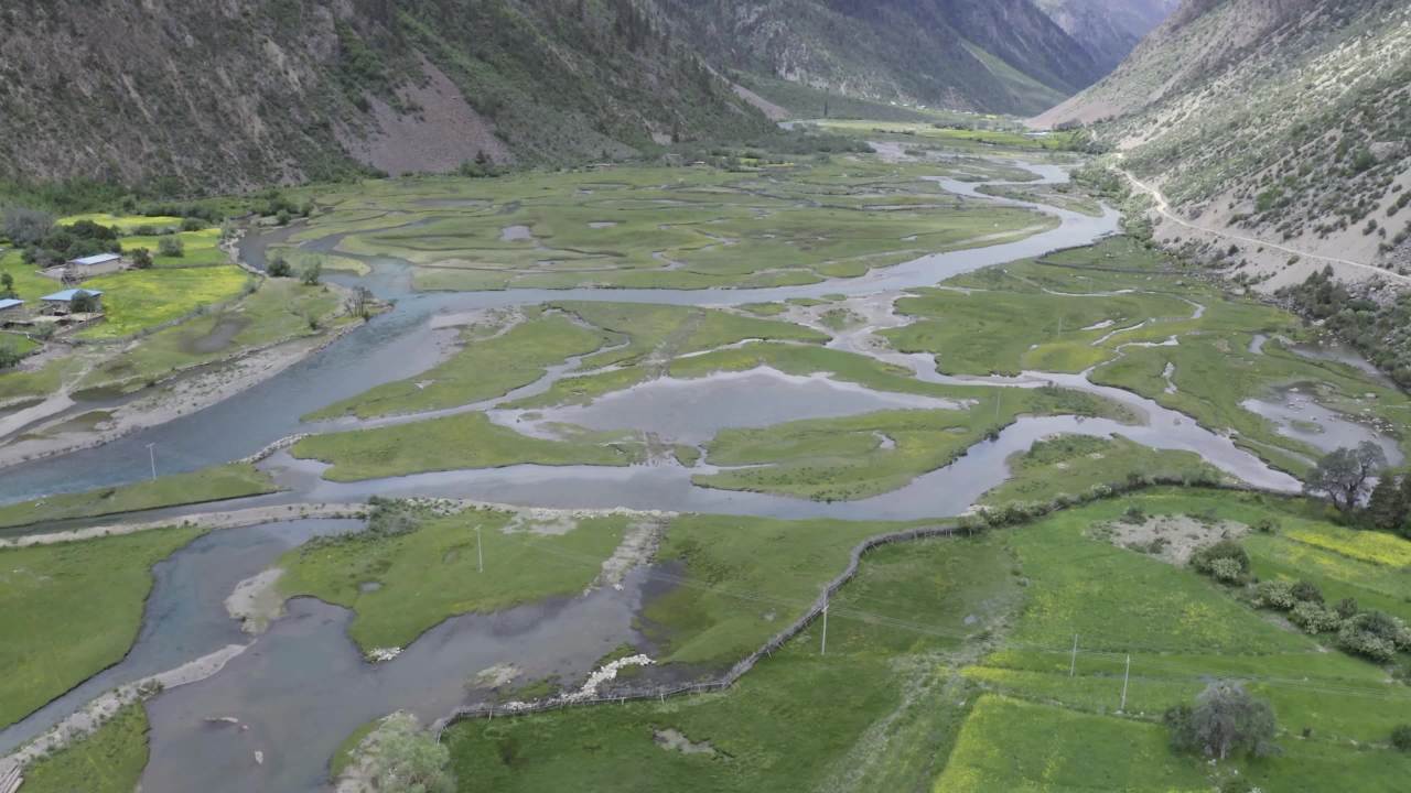 高山绿谷中蜿蜒河流与村落