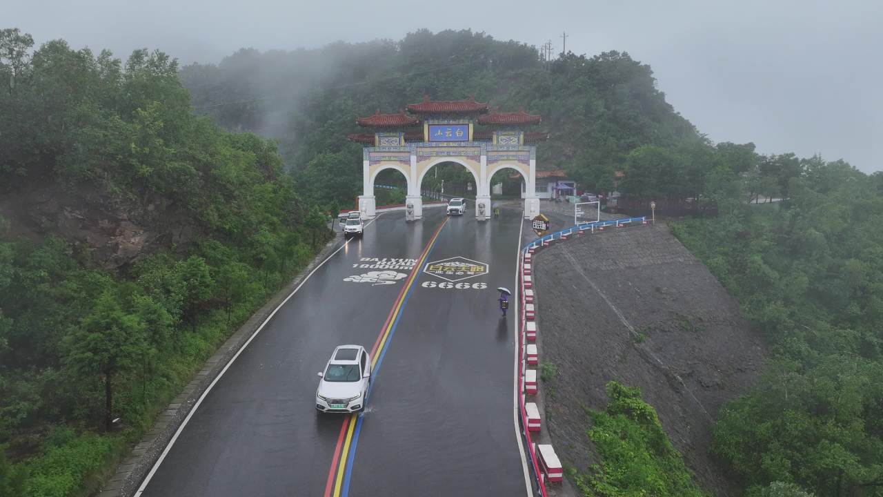 雨中山间公路与牌坊
