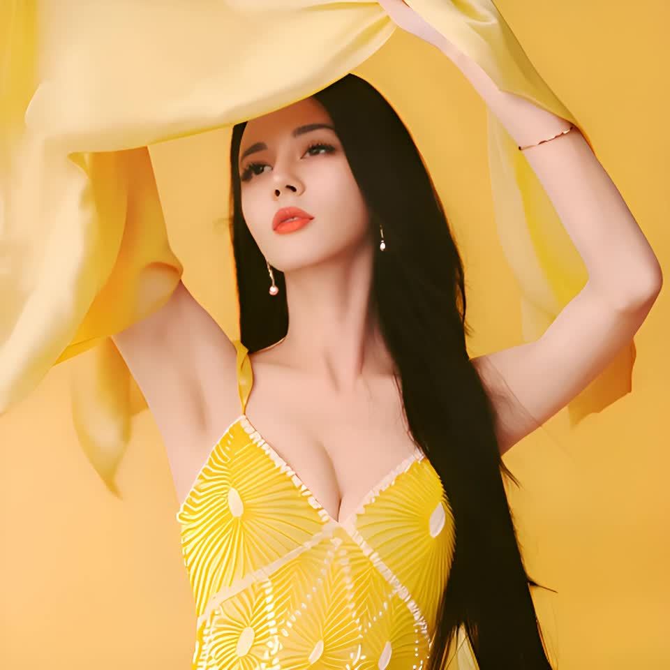 一位身穿黄色连衣裙的女子，举起一块黄色薄纱布料遮挡