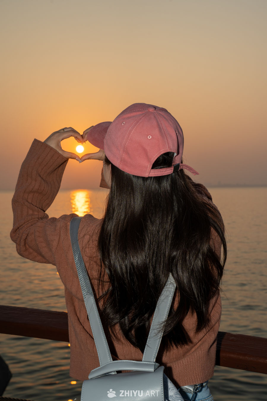 夕阳下的爱心手势