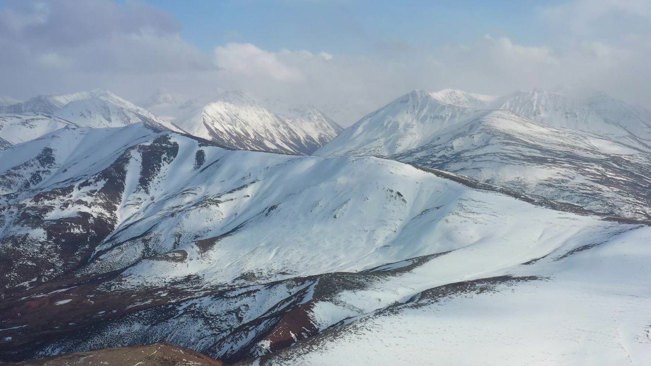 航拍风雪中的西藏洛隆县雪山风光