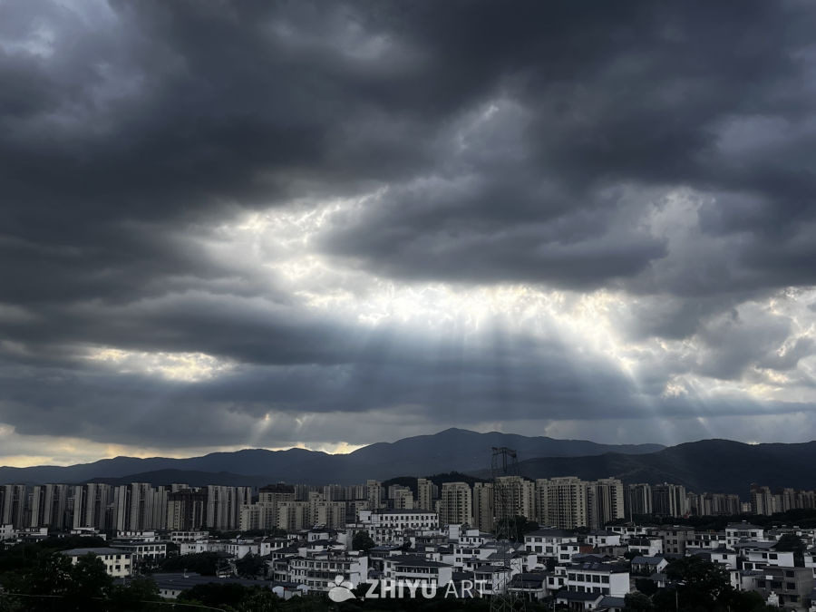 阳光穿透乌云的城市剪影