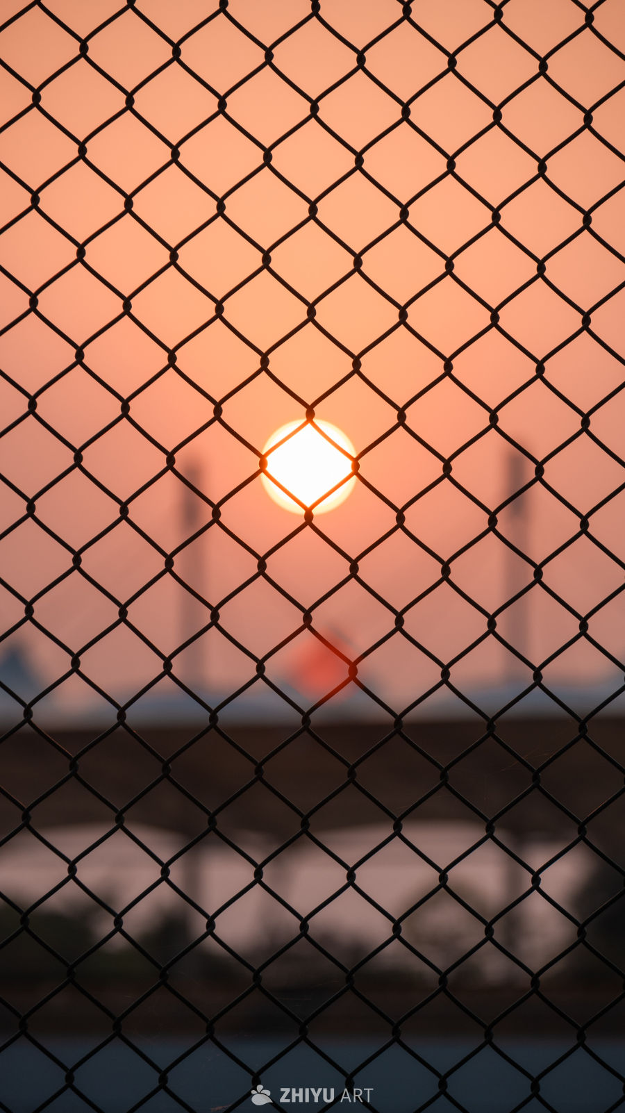 铁丝网后的夕阳工业景