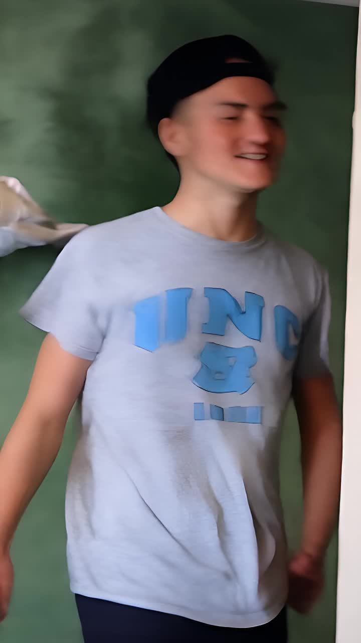 一个戴着黑色帽子、穿着带有蓝色字母“UNC”的灰色