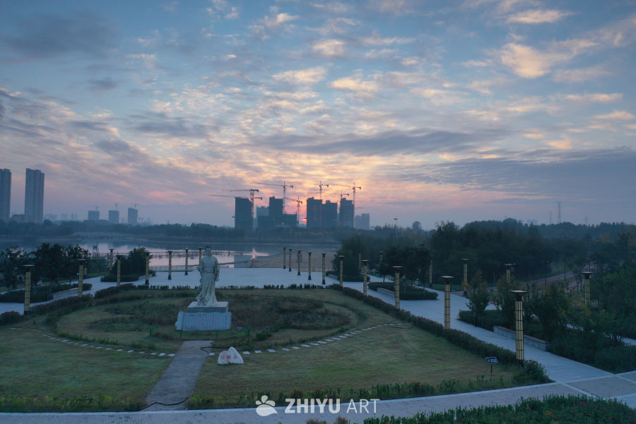 晨曦中的雕像与城市
