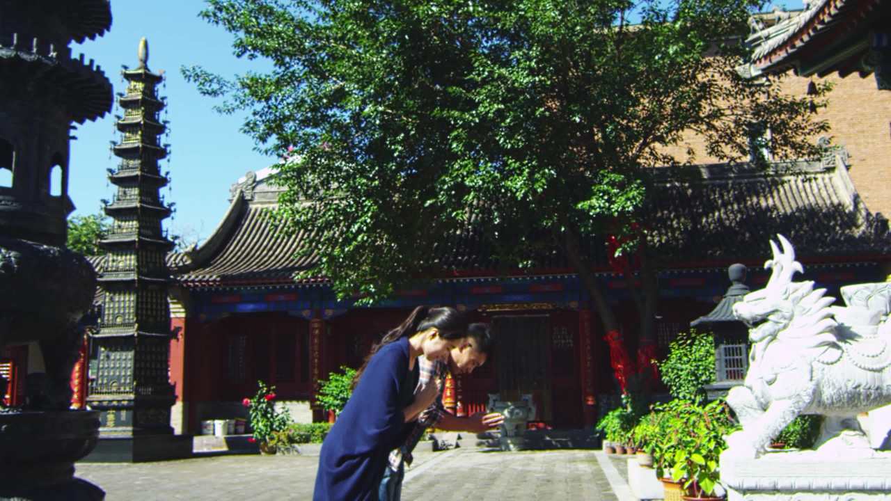 僧人引领香客进入寺院大殿