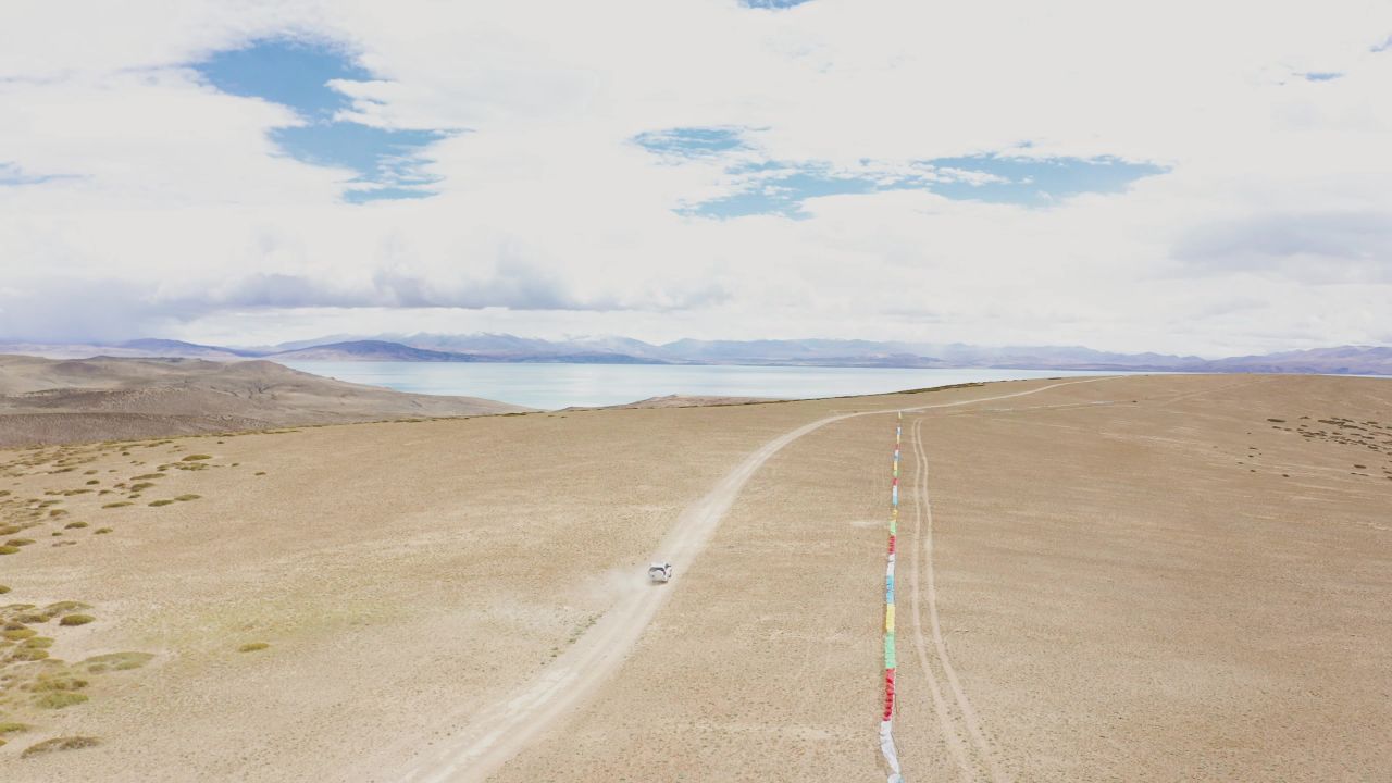 航拍越野车驶向西藏阿里玛旁雍错