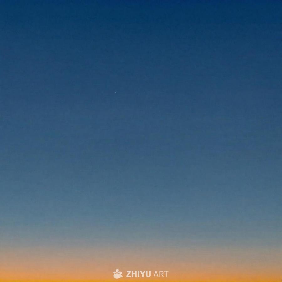 图片展示了晴朗的蓝色天空，在地平线上带有一丝橙色，